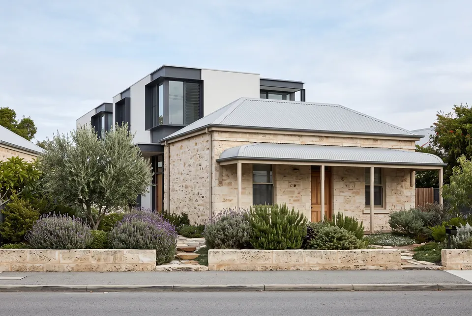 Fremantle limestone cottage with a white and dark steel two-storey addition behind