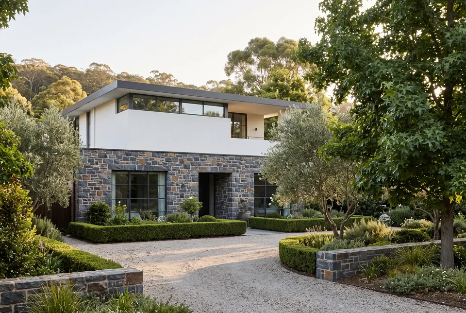 Two-storey Springfield residence with an Adelaide bluestone base, white render and a gravel forecourt